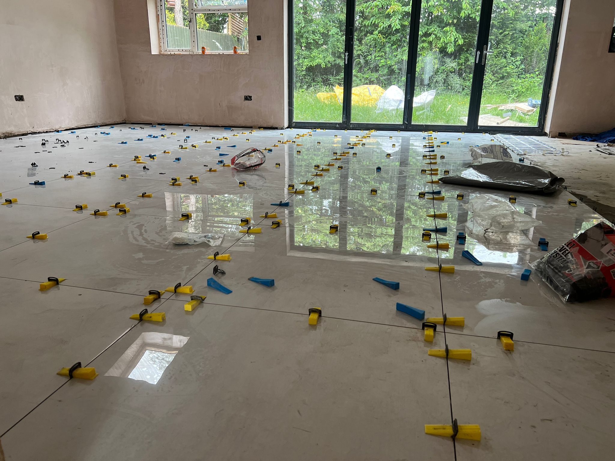 Tiling in progress with floor levelling clips and porcelain tiles