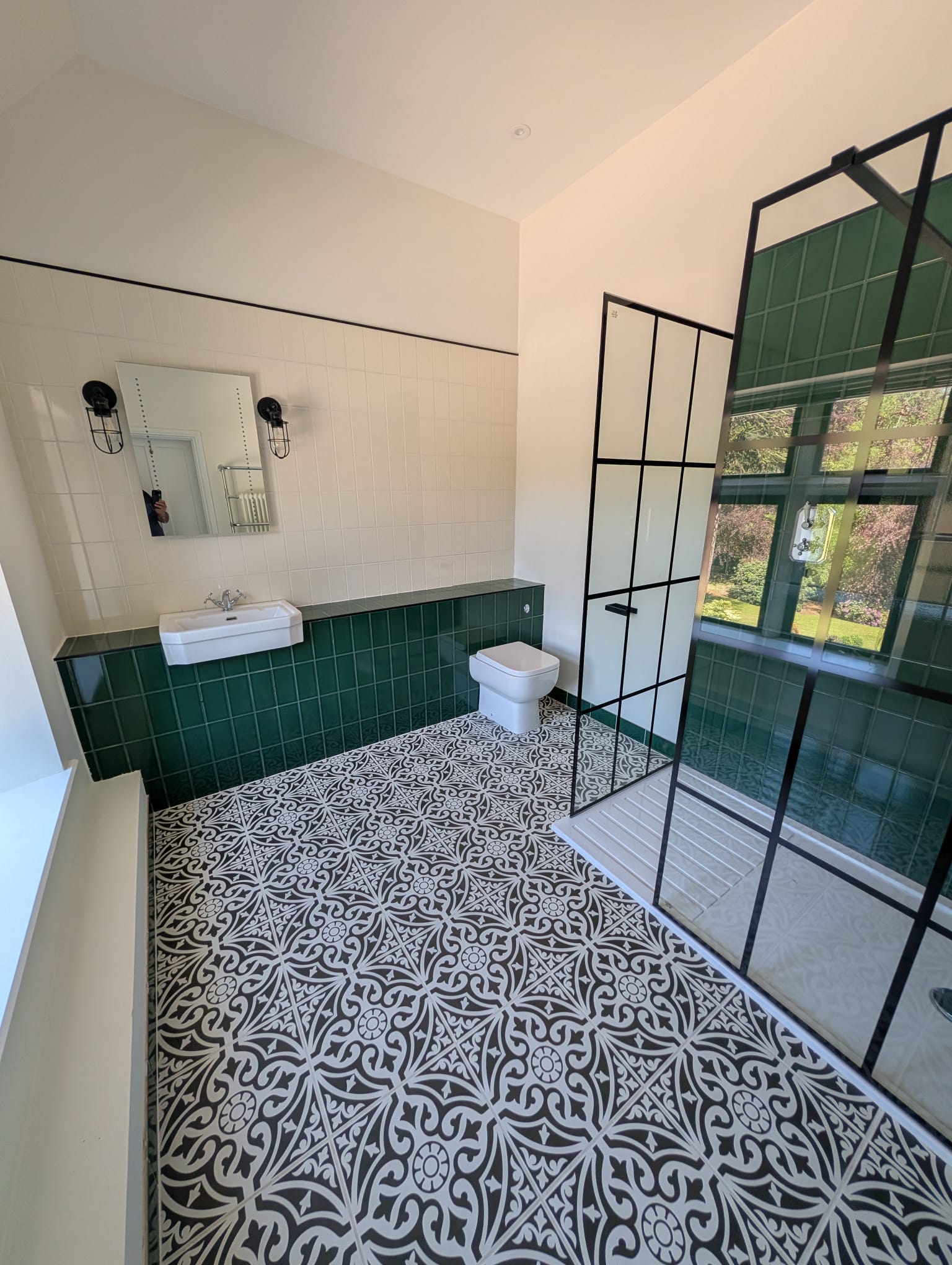 Green panel and patterned floor bathroom